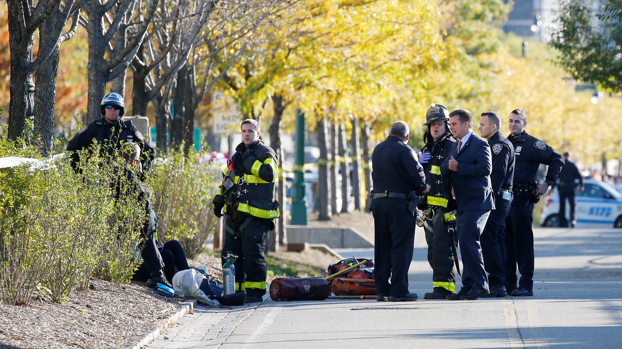   First responders stand at the crime scene on the bike path shortly after the attack  
