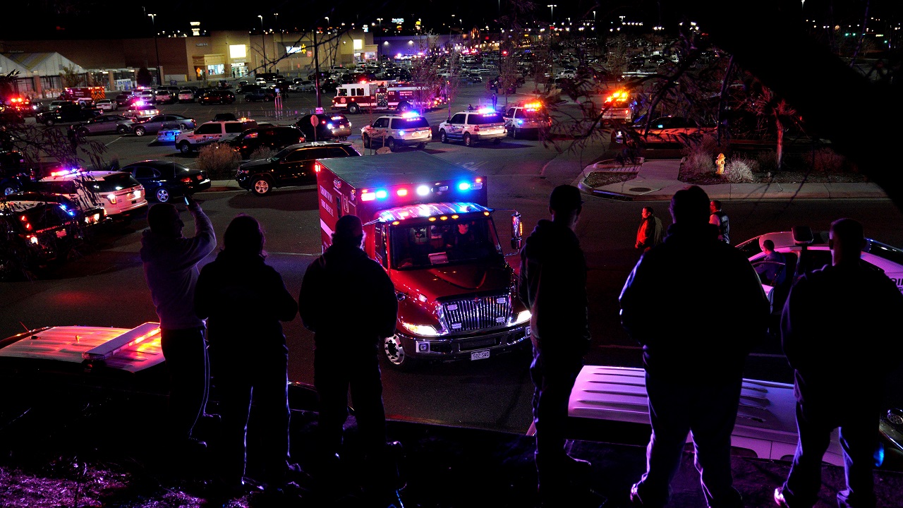   People watch an ambulance leave the shooting scene  
