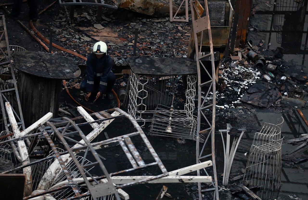   A firefighter rests amidst debris at a restaurant destroyed in a fire in Mumbai. (Image Courtesy: Reuters)  