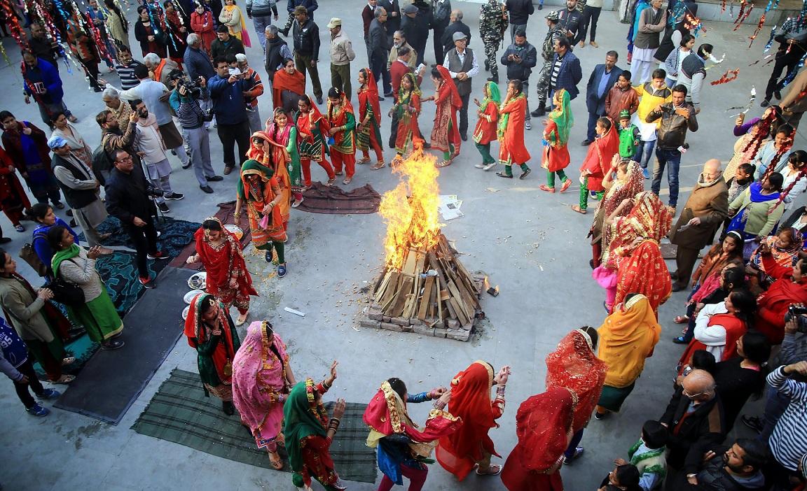    Girls dressed in their traditional attire dance around a bonfire as they celebrate Lohri in Jammu on Saturday. PTI   