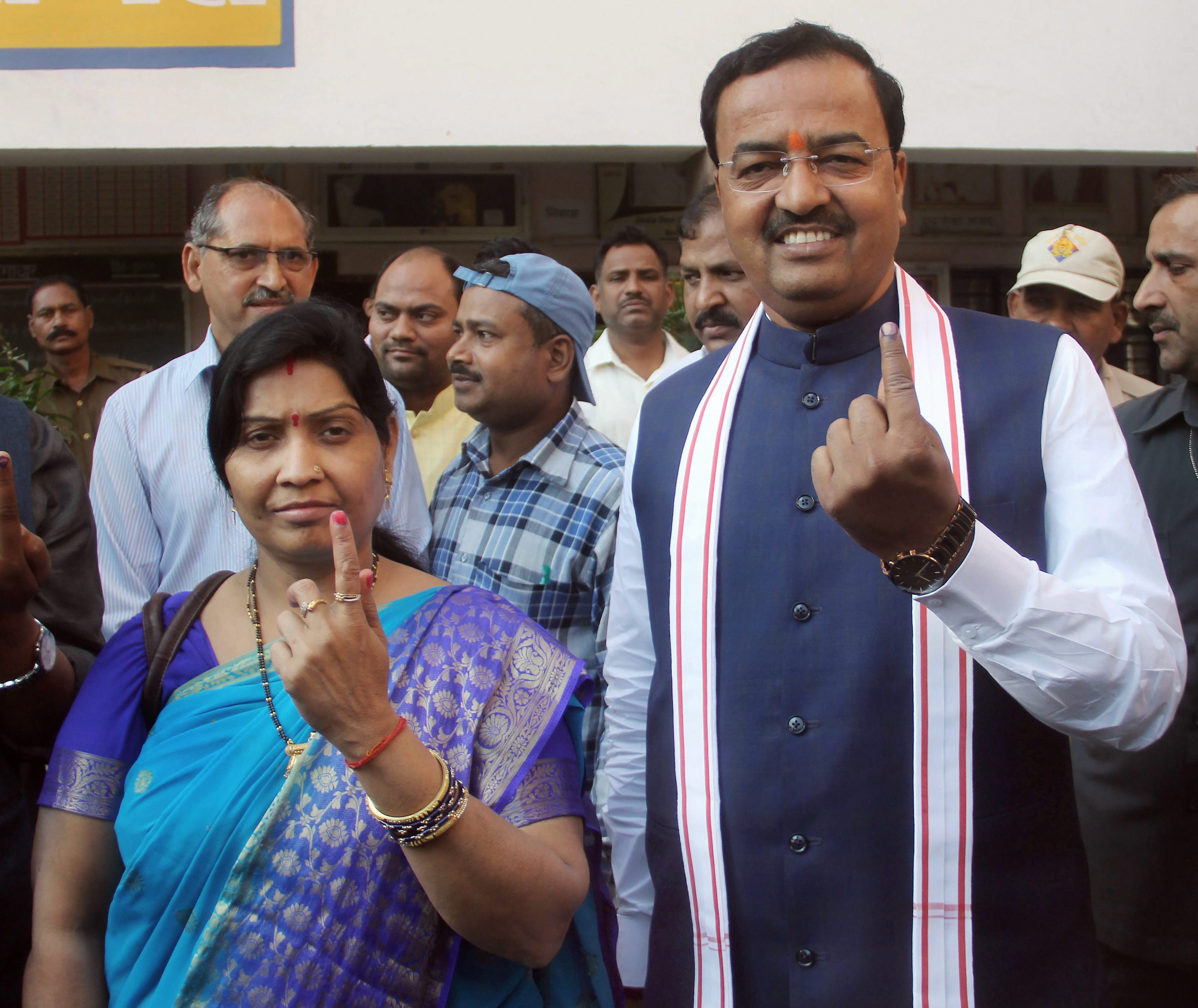  Allahabad: Uttar Pradesh Deputy Chief Minister Keshav Prasad Maurya and his wife Raj Kumari Maurya show theirs marked with indelible ink after they cast their votes during Phulpur Lok Sabha by-poll election, in Allahabad on Sunday. 