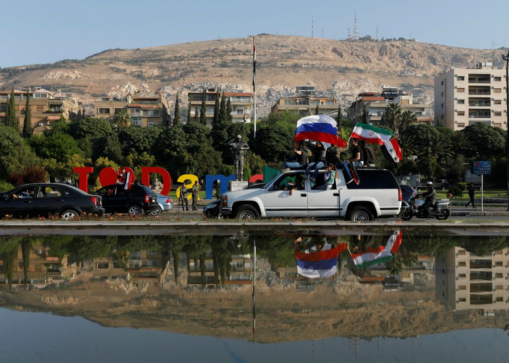  Russian, Syrian and Iranian flags were seen during protests against the air strikes in Damascus. Image: Reuters 