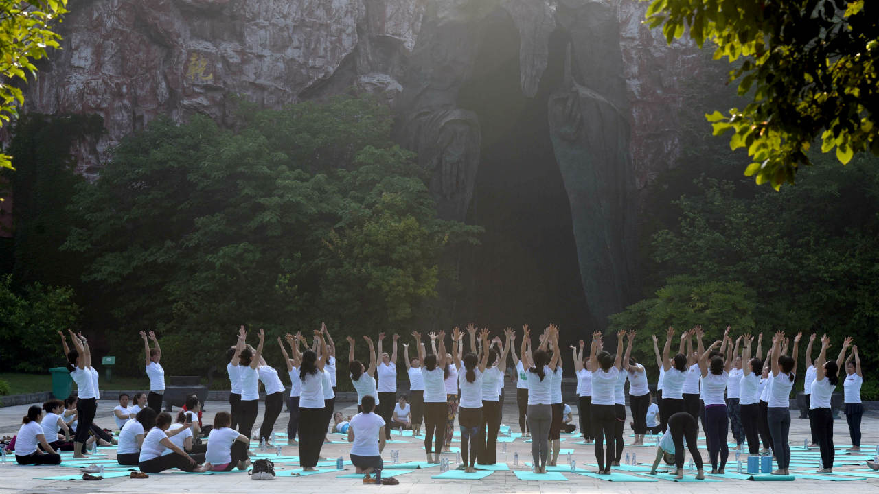  People practise yoga on International Yoga Day in front of a giant Laozi statue in Jiangsu province of China. (Image: Reuters ) 