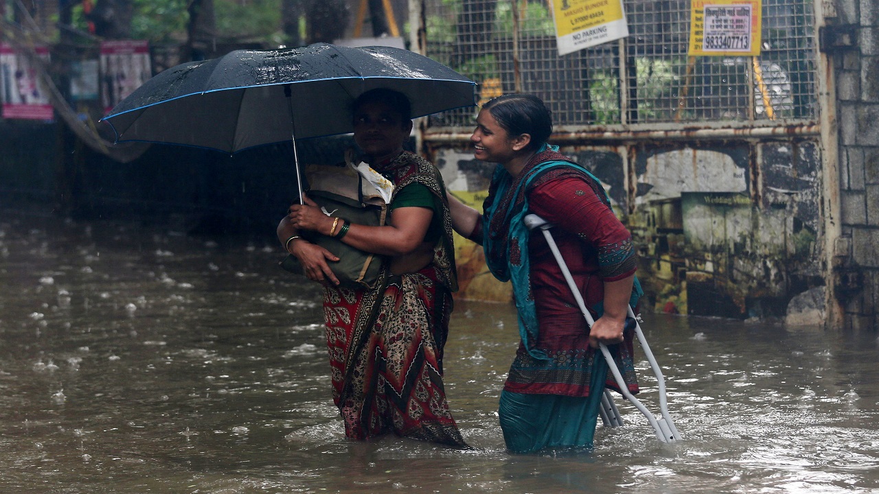  People wade through a waterlogged street during heavy rains in Mumbai (Image: Reuters) 