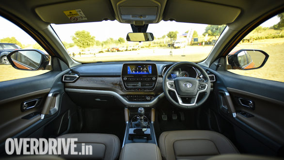 <p>Taking centrestage in the cabin, is a floating 8.8-inch touchscreen. The top of the dashboard is covered in soft touch plastic, followed by a textured wood finish, and further down there&#39;s a perforated leather-wrapped cavity to stow knick-knacks.</p>