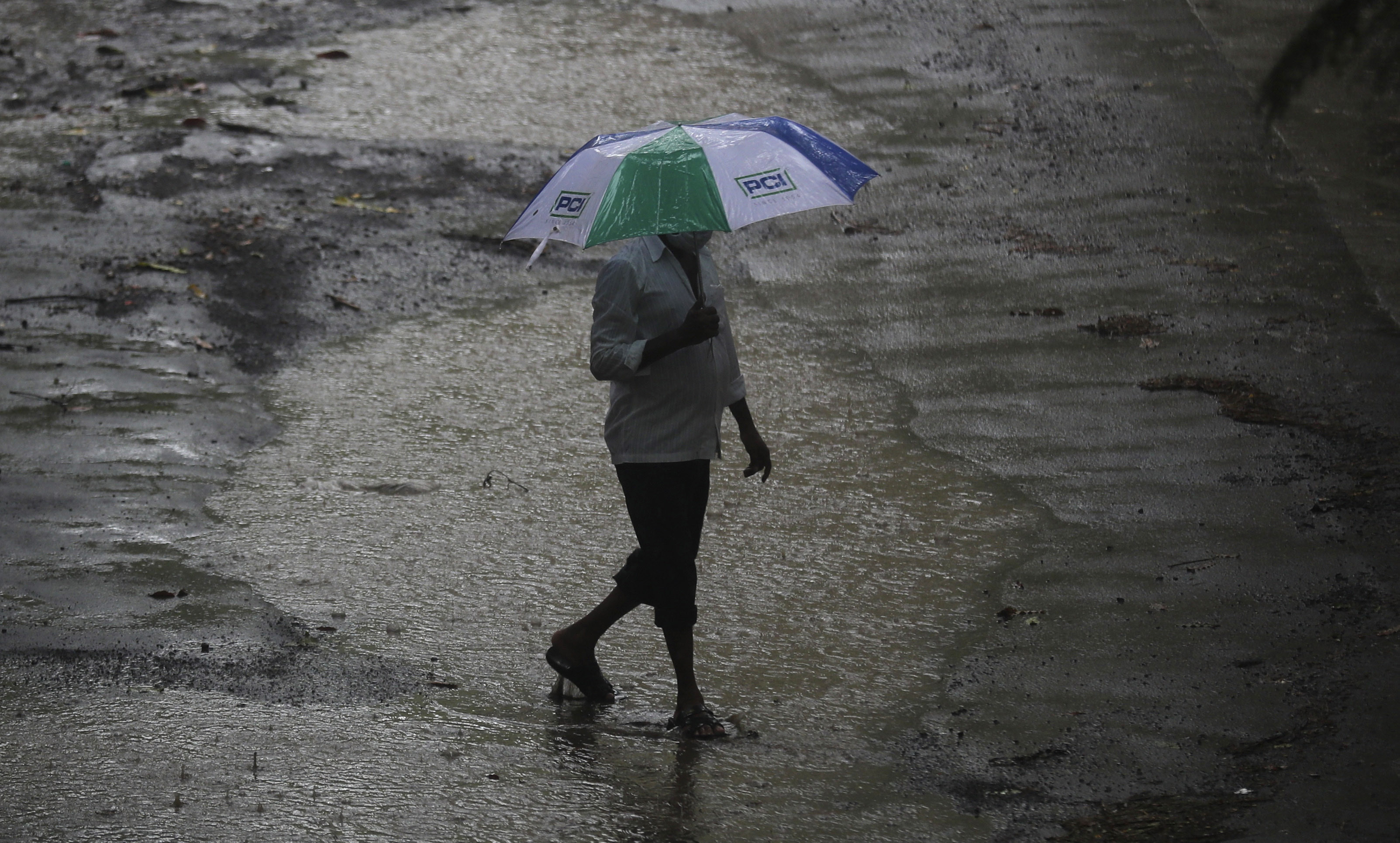  A man holds an umbrella and walks in the rain in Mumbai on Thursday. 

  Source: AP Photo  
