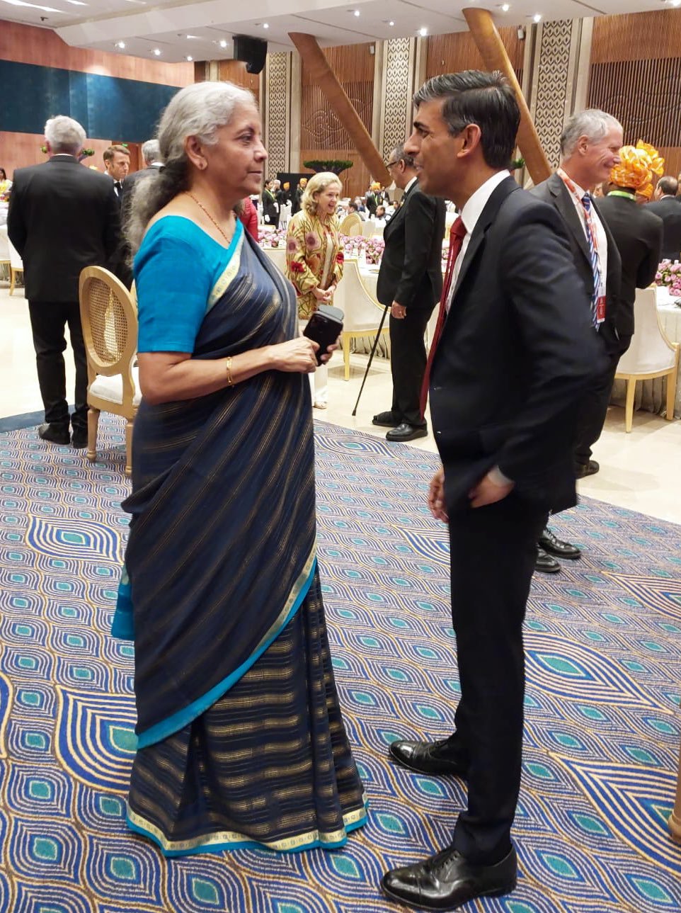  Finance Minister Nirmala Sitharaman exchanges pleasantries with UK PM Rishi Sunak during Ratri Bhoj par Samvad at Bharat Mandapam in New Delhi. 